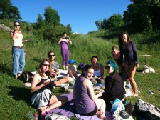 Yoga teacher trainees enjoy potluck next to fjord.